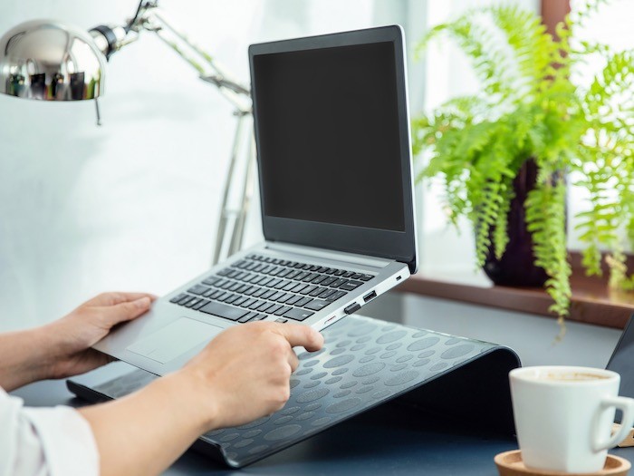 A desk with a laptop on a stand.